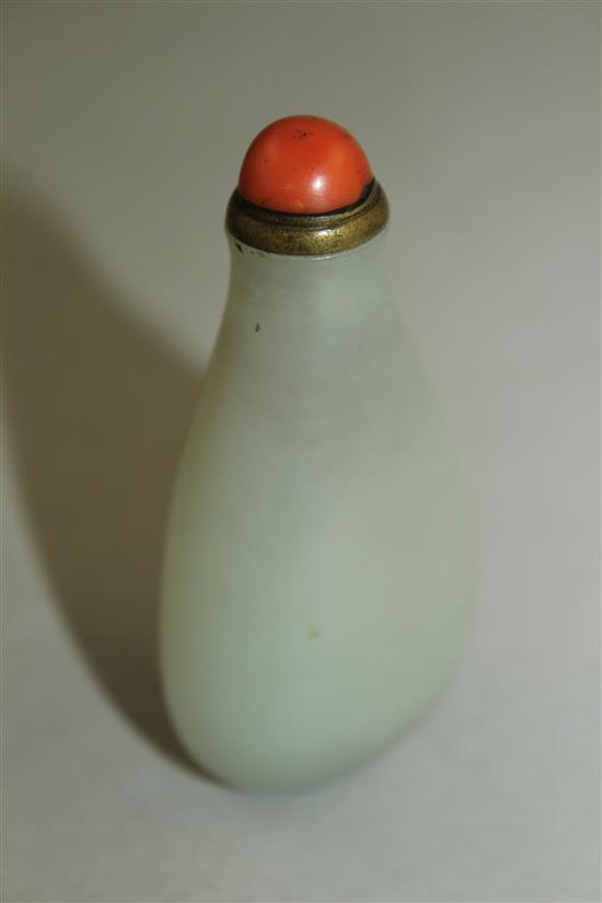 A Chinese pale celadon jade pear shaped snuff bottle, 1750-1850, 6cm, brass and coral stopper